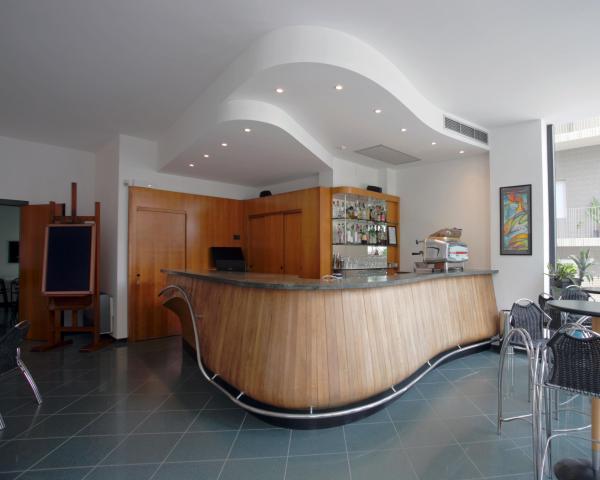 Moderno bar con bancone in legno e sedie in metallo.