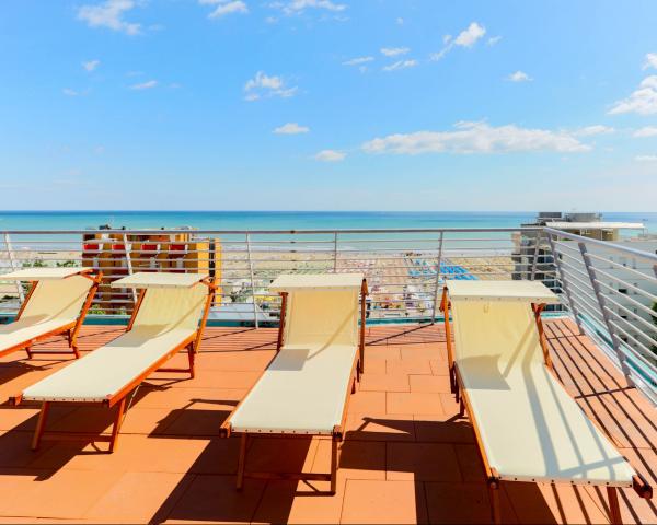 Sdraio su terrazza vista mare, cielo sereno.